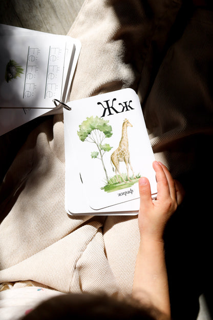 Child holding a giraffe alphabet card — Russian alphabet cards